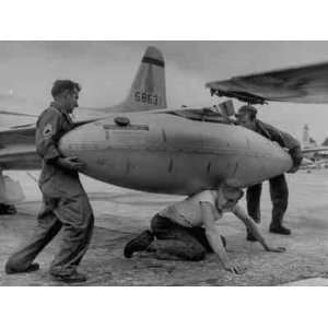 com Ground Crew Members Attaching Tanks to Wing Tips of US Jet Plane 